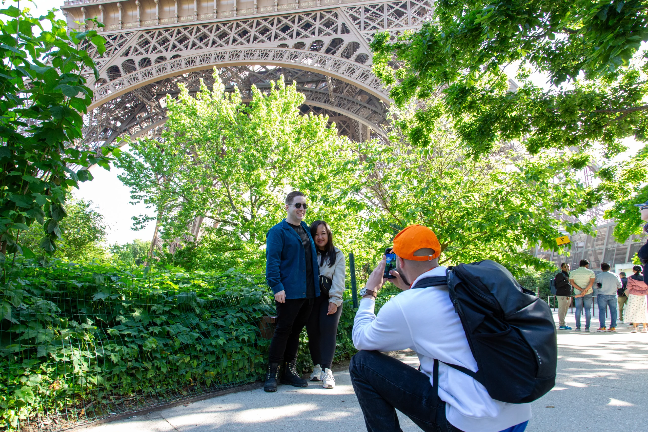 Guide taking photo of travelers with Eiffel Tower during guided tour in Paris