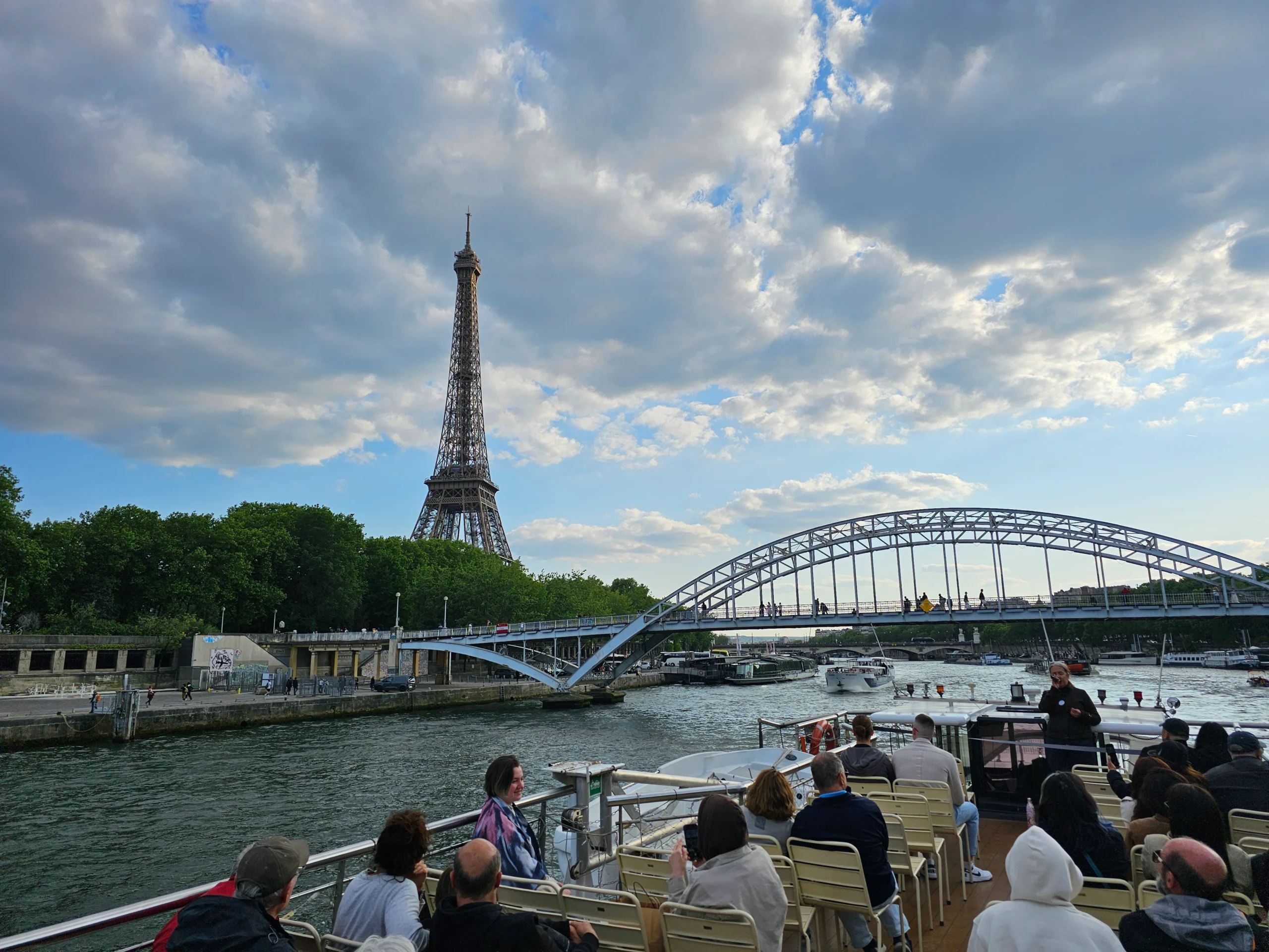 Passengers on Seine River cruise and Eiffel Tower in Paris