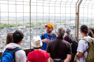 Tour Guide explaining during Eiffel Tower Guided Climb with scenic background view