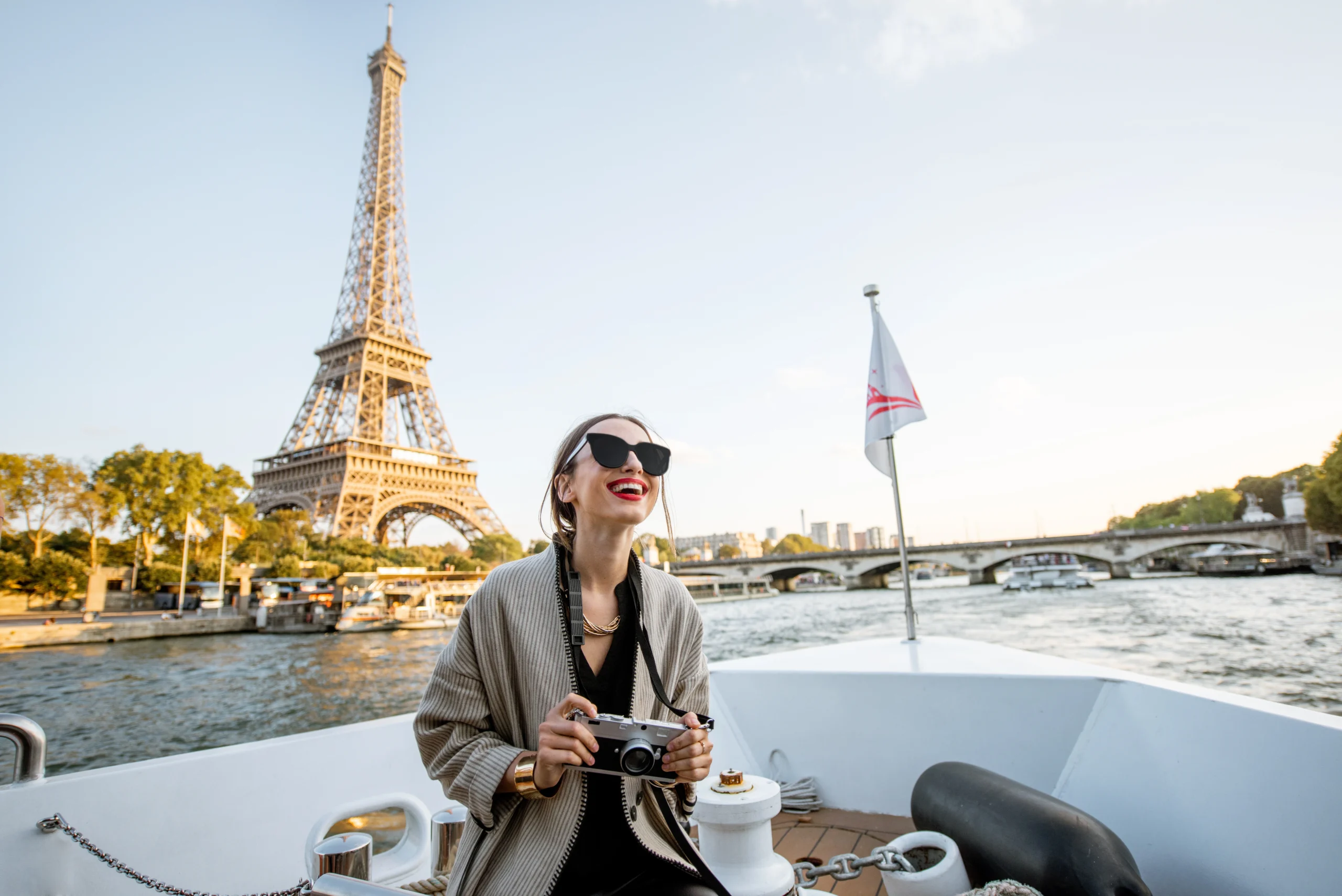Young woman enjoying beautiful landscape view on the riverside from a private boat in Paris