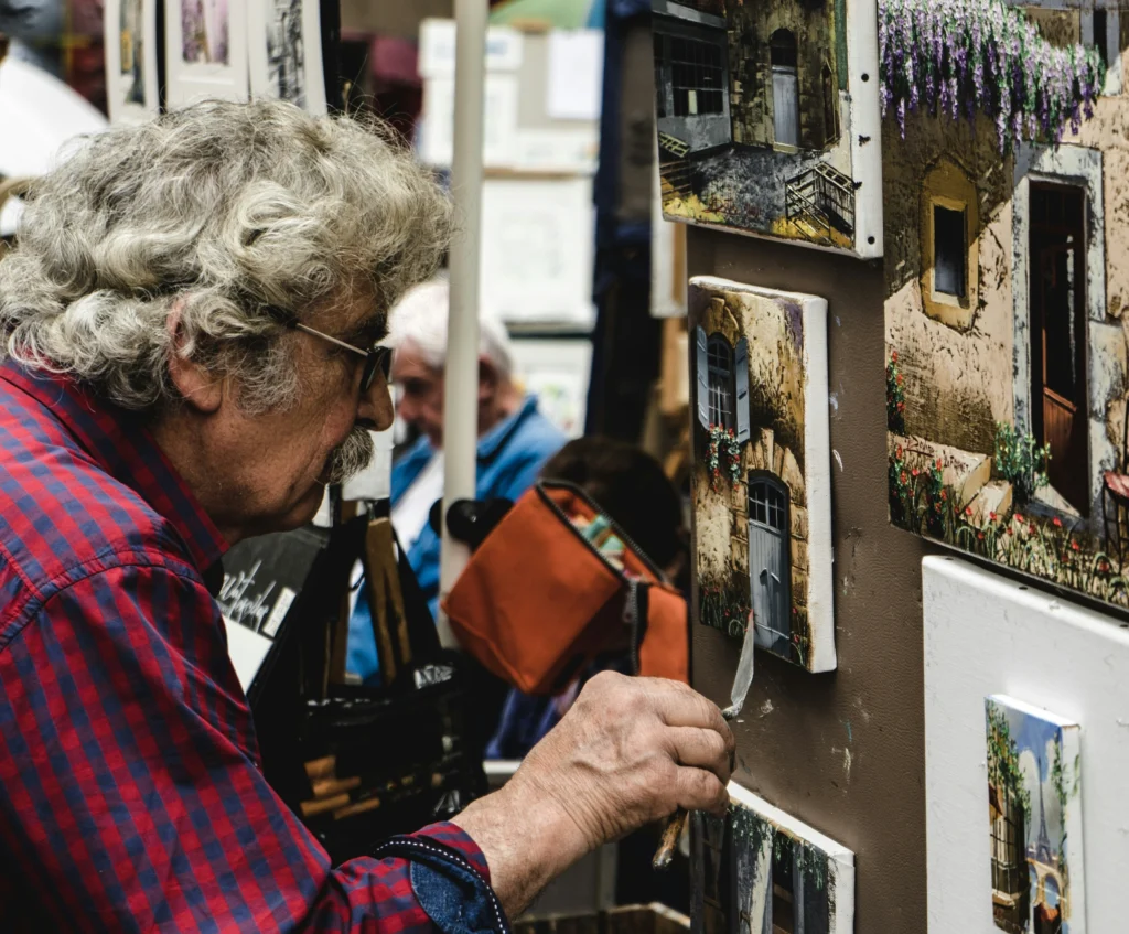 Man standing in front of displayed paintings